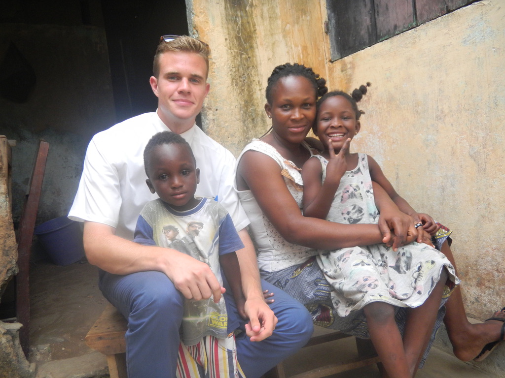 Tanner sitting with an African family.